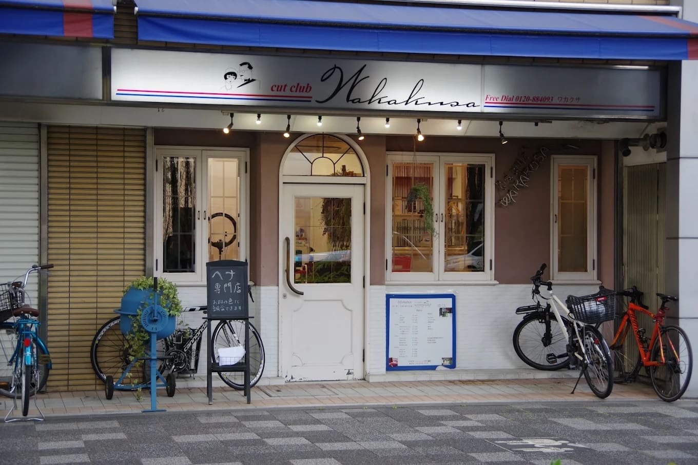 Magazinul are un semn pe care scrie "cut club Wakana" deasupra unei uși duble albe și oferă servicii de scurtături și henna. Între ferestre și parcarea pentru biciclete, există rafturi albastre pentru biciclete, plante de apartament și meniuri și semne lângă intrare.